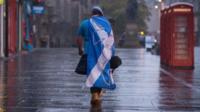 A lone "YES" campaign supporter walks down a street in Edinburgh