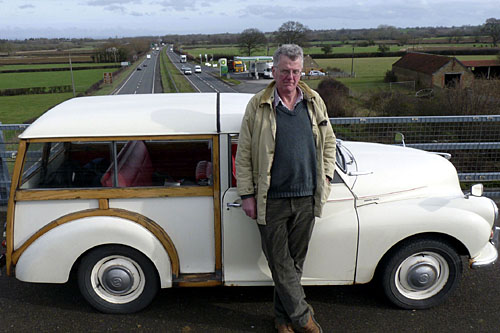 Tom Fort standing by the 1968 Morris Traveller on a bridge above the A303.