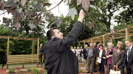 man next to copper tree