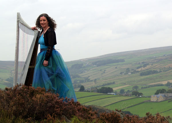 Fiona Katie Roberts with her harp on top of the Yorkshire Moors