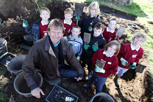 Michael Wood looking at finds with schoolchildren in Old Deer 