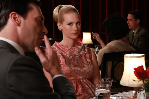 Don Draper, played by Jon Hamm, smokes in front of on-screen wife Betty Draper, played by January Jones
