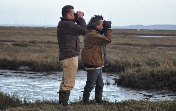 Chris Packham and Martin Hughes-Games looking through binoculars