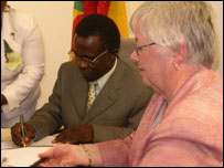 Grenadian Prime Minister Keith Mitchell signing the agreement with US Ambassador Mary Kramer 
