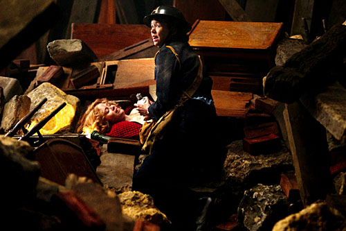 Kay, played by Anna Maxwell-Martin, stands over Helen, played by Claire Foy, lying in the rubble.