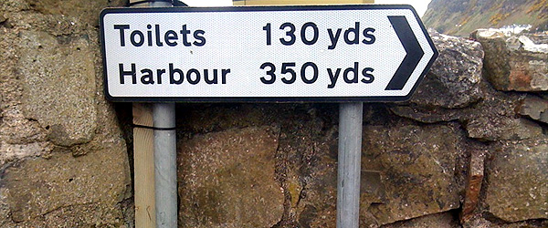 A road sign measuring the distance of travel in yards rather than miles