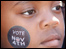 child with vote paint sign on his cheek