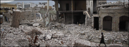 person walks through rubble in Port-au-Prince