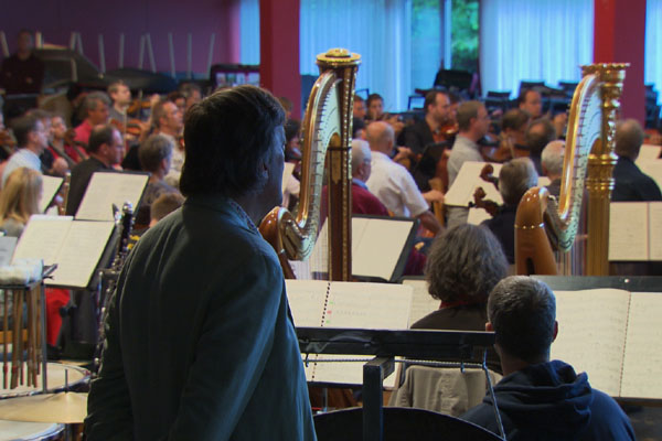 Stephen Fry watches the orchestra rehearse for the Bayreuth Festival
