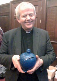 The Reverend Nick Holtam with a pot of coins donated to the Radio 4 Christmas Appeal