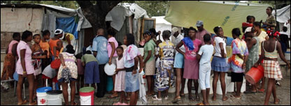 Earthquake survivors collect water in a provisional camp in Port-au-Prince