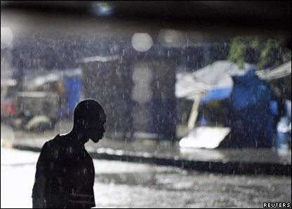 A man walks in the rain at downtown Port-au-Prince