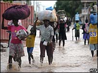 people walking through flooded streets