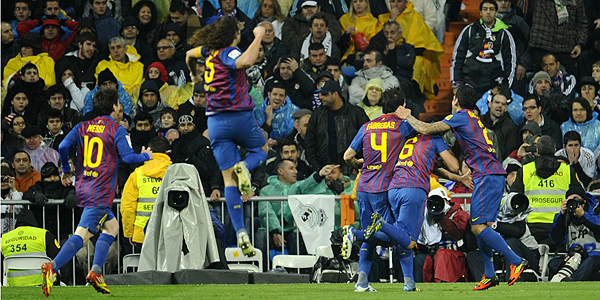 Barcelona's players celebrate after Real Madrid's Brazilian defender Marcelo scored an own goal during the 'El clasico' Spanish League football match Real Madrid against Barcelona at the Santiago Bernabeu stadium in Madrid on December 10, 2011