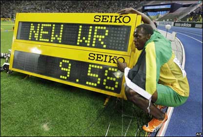 Usain Bolt stands next to his latest world record