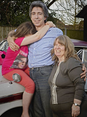 Maisie, held by her adoptive father Jim, and her adoptive mother Sue