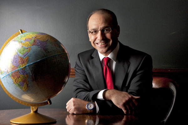Theo Paphitis sits next to a giant globe
