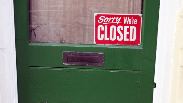 door with closing down sign