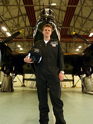 Jake Humphrey, with helmet in hand, standing in front of a RAF bomber