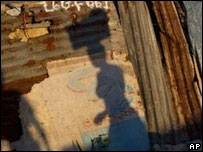 Shadows of people on a wall in a camp in Port-au-Prince